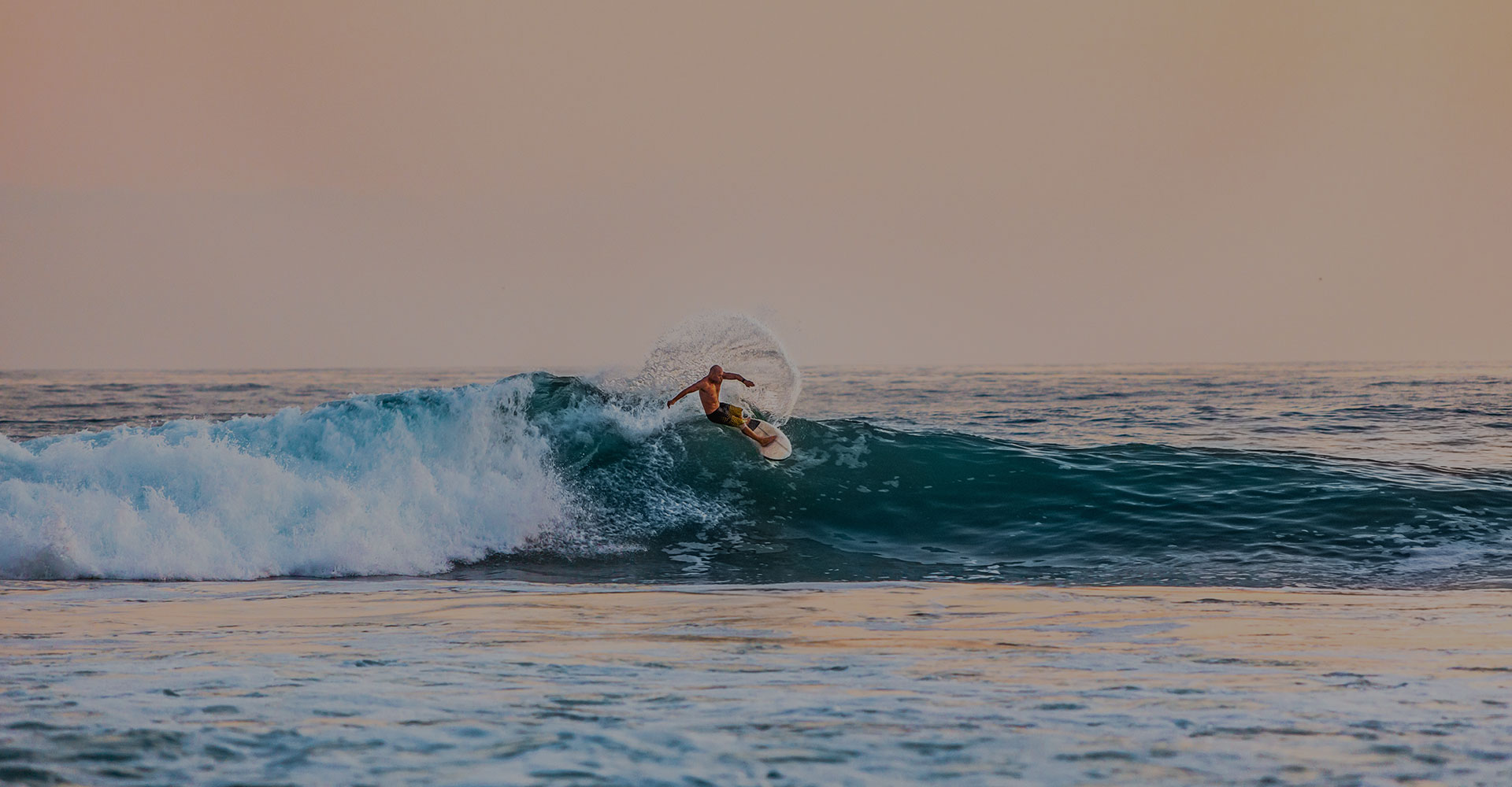 Surfer riding the waves of the Hikkaduwa beach