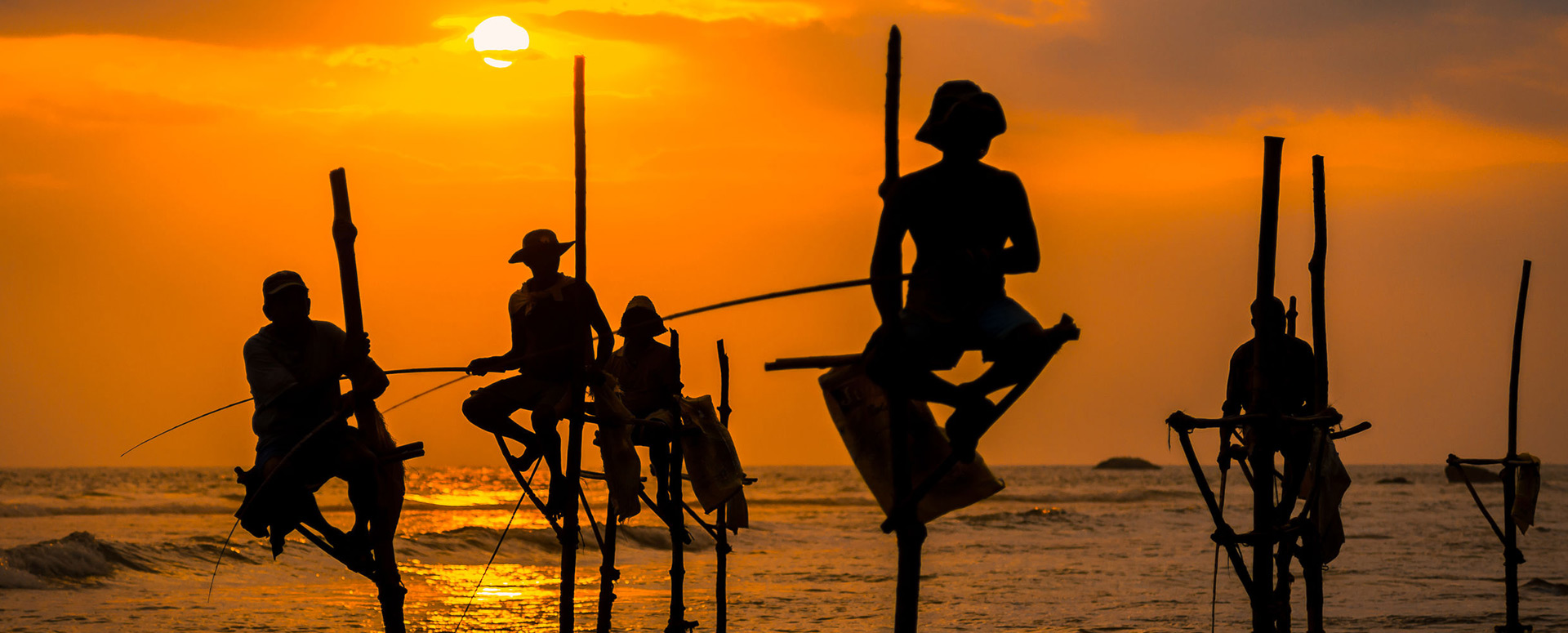 Silhouettes of the traditional Stilt fishermen during sunset