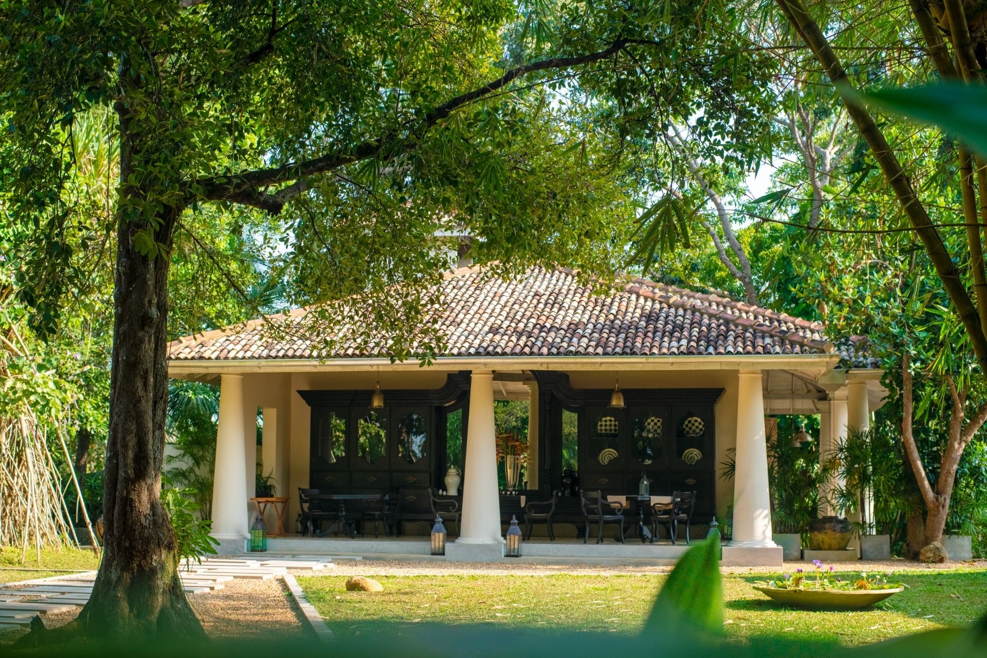 Outdoor Seating area surrounded by lush greenery at Haritha Villas + Spa